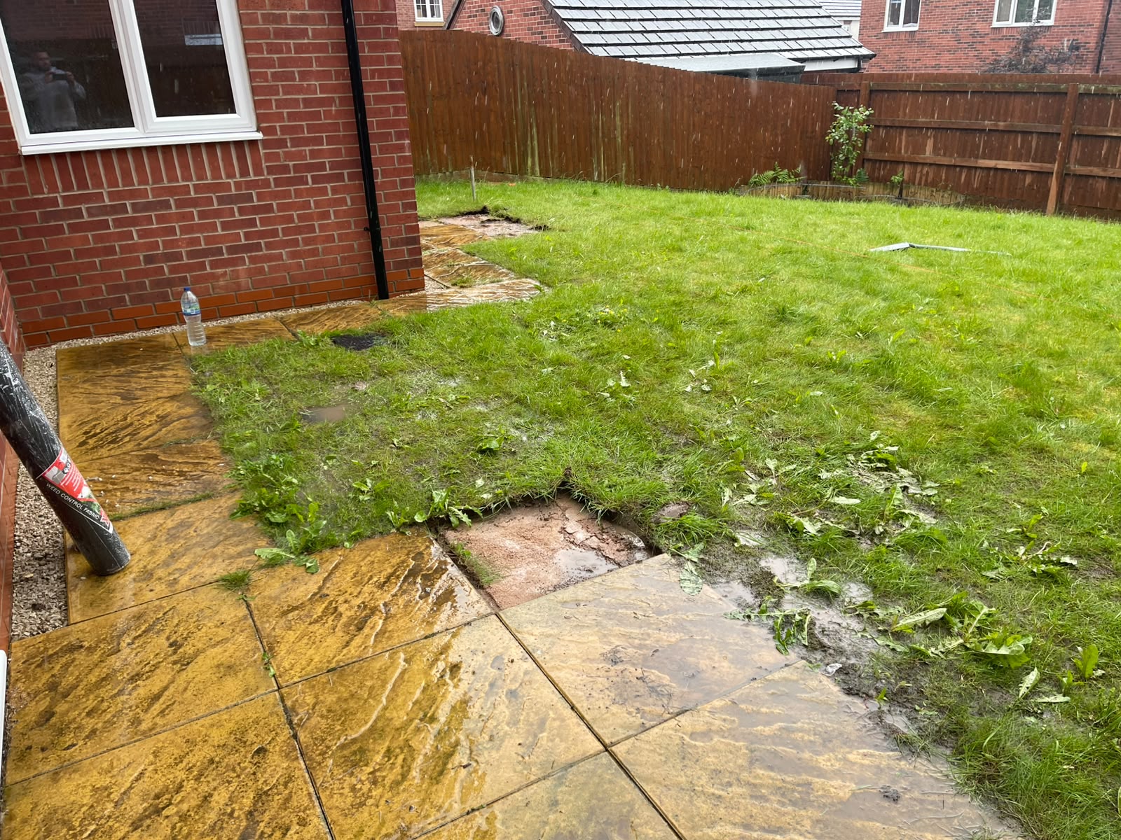 Old uneven flagstones being lifted before replacement work